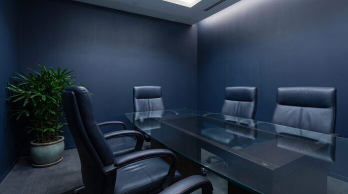 Five empty executive chairs around a glass table, with no names or logos, a visu Five empty executive chairs around a glass table, with no names or logos, a visual for what AI leaders signaled for 2026 content